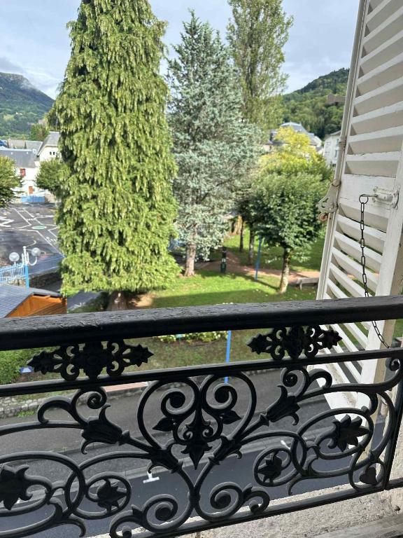 a balcony with a wrought iron railing and a tree at Studio 17 1 chambre in La Bourboule