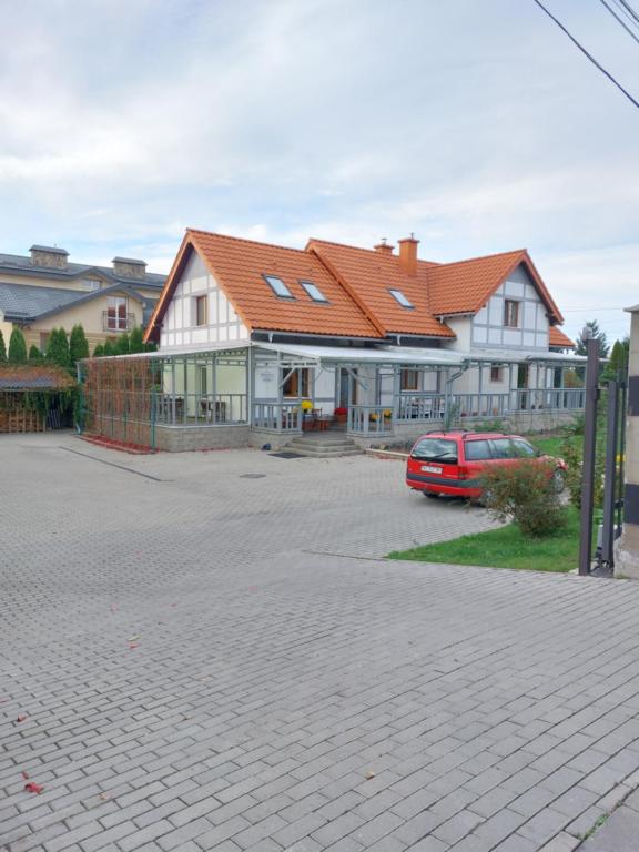 a house with a car parked in front of it at Пансіон АГАВА in Novovolynsʼk