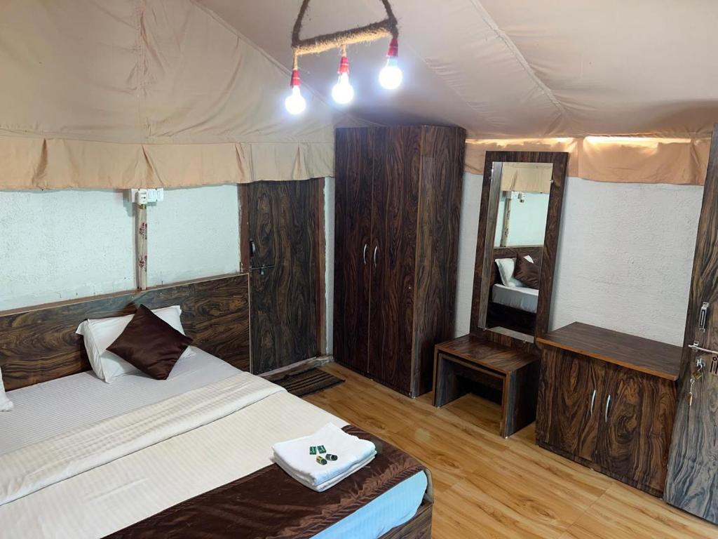 a bedroom with a bed and a mirror at Satpura Adventure Resort in Pachmarhī