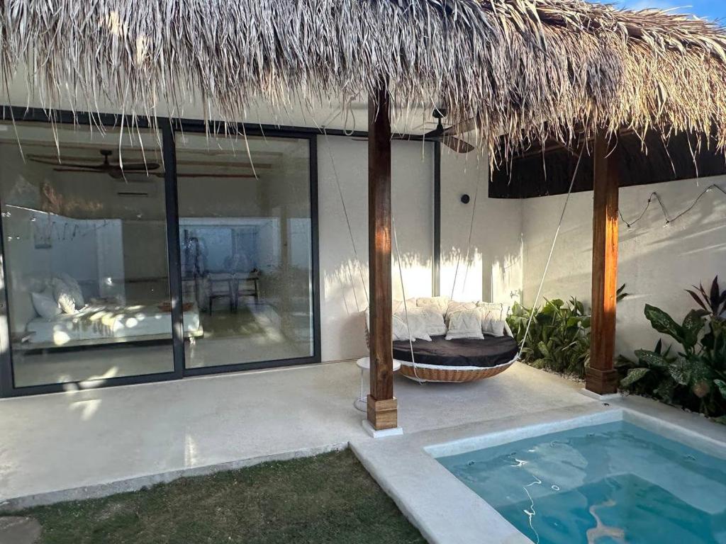 Casa con piscina y sombrilla de paja en Hoshi Villas, en General Luna
