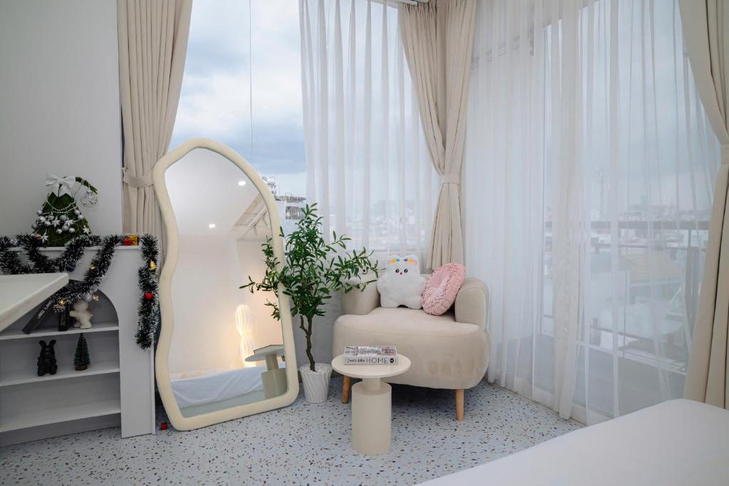a bedroom with a mirror and a chair and a window at Four P Home and Studio in Ho Chi Minh City