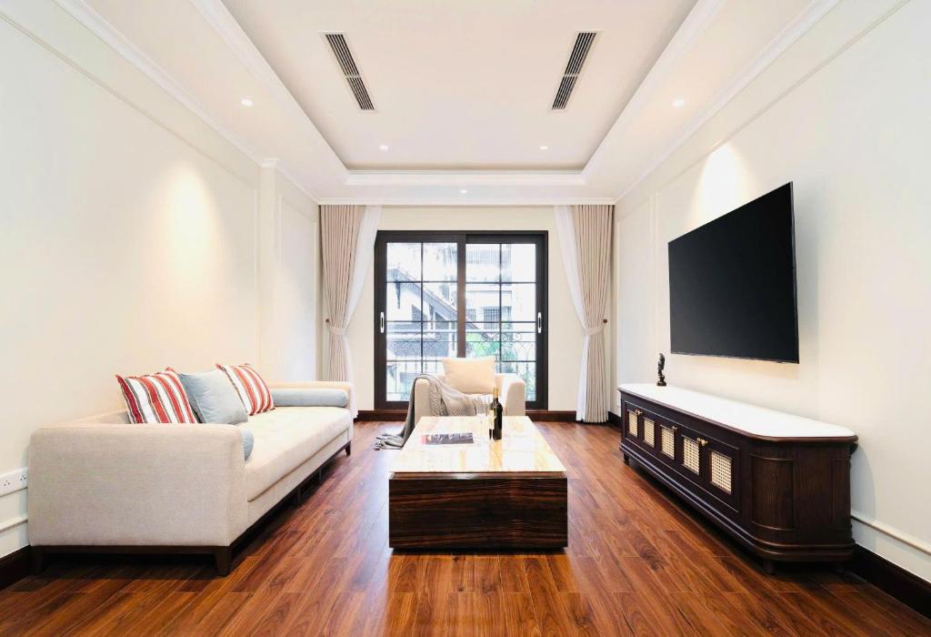 河内The Harmony Central Suites Ha Noi的客厅里有一张沙发和一台电视