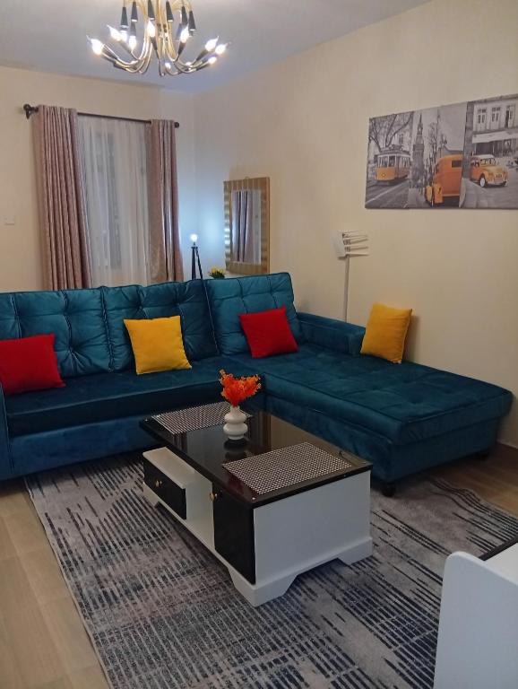 a living room with a blue couch and a coffee table at JO kitengela deluxe Two and one bedroom in Kitengela 