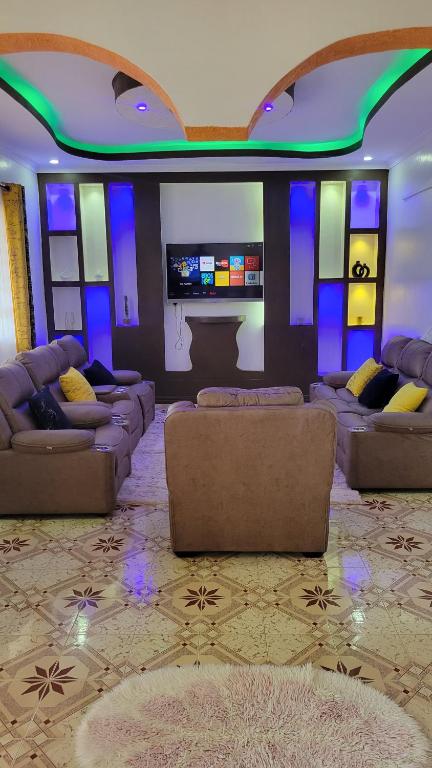a living room with couches and a flat screen tv at Ashton cosy homes in Nakuru