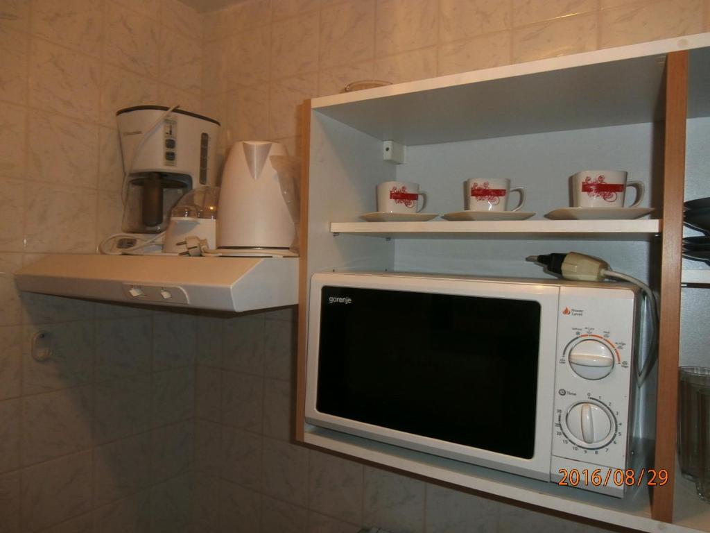 a microwave sitting on a shelf in a kitchen at Apartments Meni in Drage