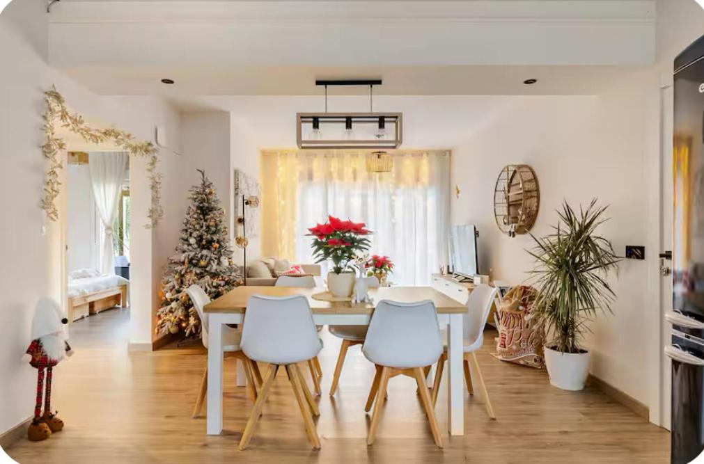 ein Wohnzimmer mit einem Tisch, Stühlen und einem Weihnachtsbaum in der Unterkunft O Lar de Laura in Vigo