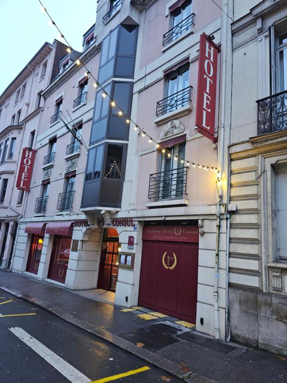 un bâtiment avec des lumières sur une rue dans l'établissement Hôtel 1er Consul Rouen, à Rouen