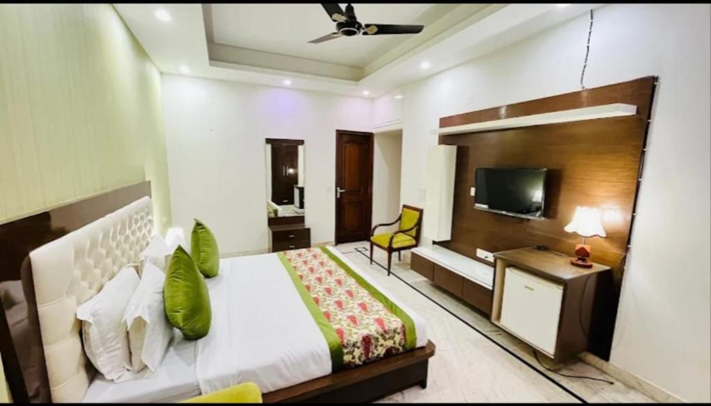 una habitación de hotel con una cama y un televisor en ES tower, en Gumgaon