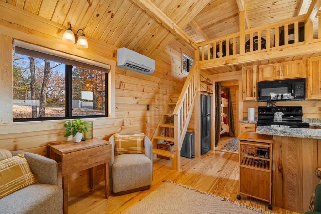 a log cabin with a living room and a staircase at P-Bay The Roost home in Reeds Spring