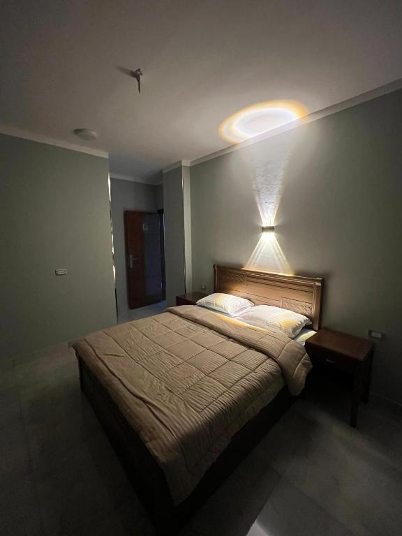 a bedroom with a bed and a light on the wall at Gamandy Hostel in Luxor