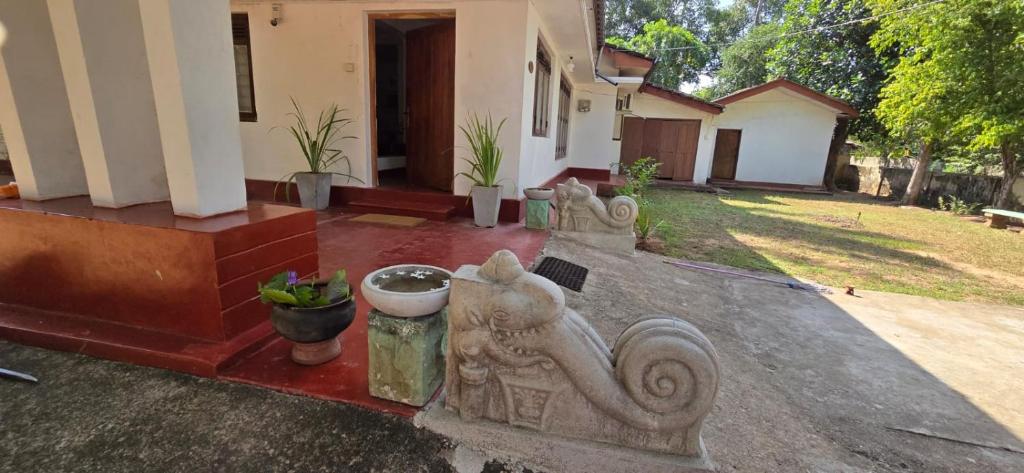 阿努拉德普勒Nature's Touch Villa的一栋房子，门廊上摆放着一尊猴子雕像。