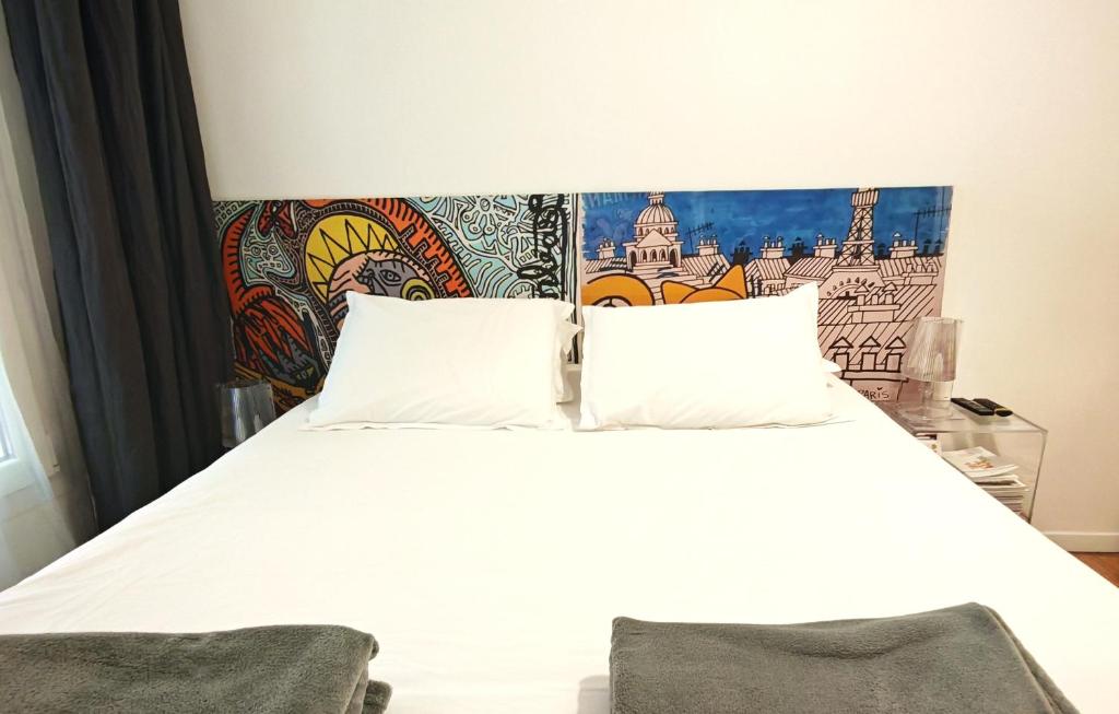 a bedroom with a white bed with a colorful headboard at Studio centre historique derrière rue d'Italie - Climatisé in Aix-en-Provence