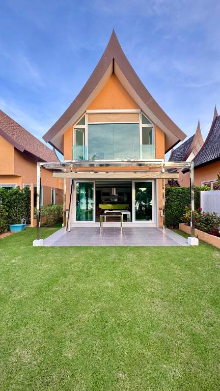 a house with a bench in the middle of a yard at Juga Beach Front Villa 3B Koh Chang in Ko Chang