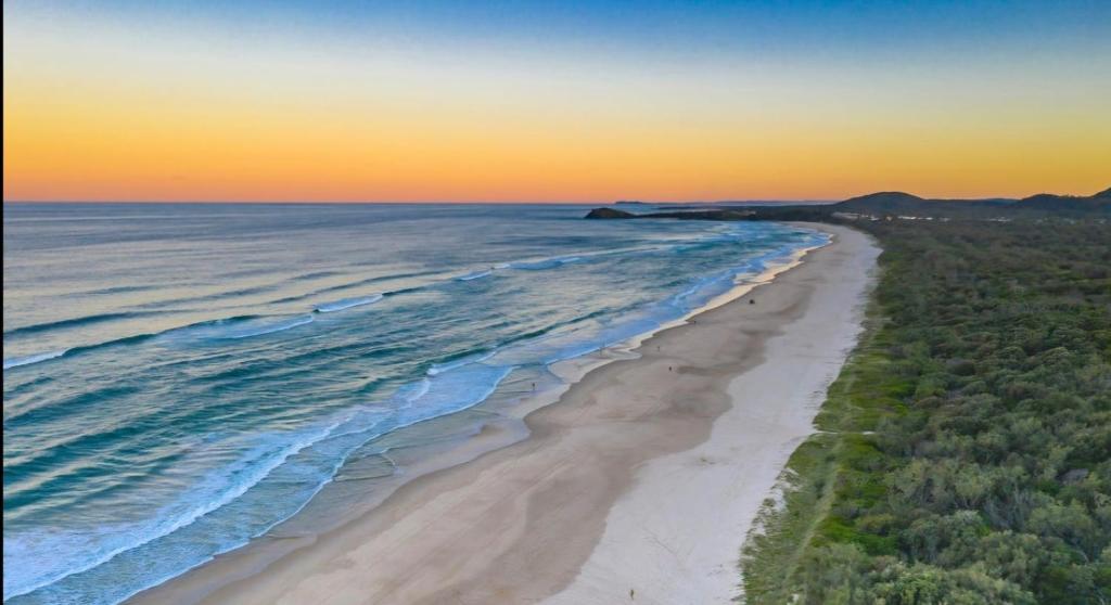 - une vue aérienne sur la plage au coucher du soleil dans l'établissement Bugluma - Cotton Beach, à Casuarina