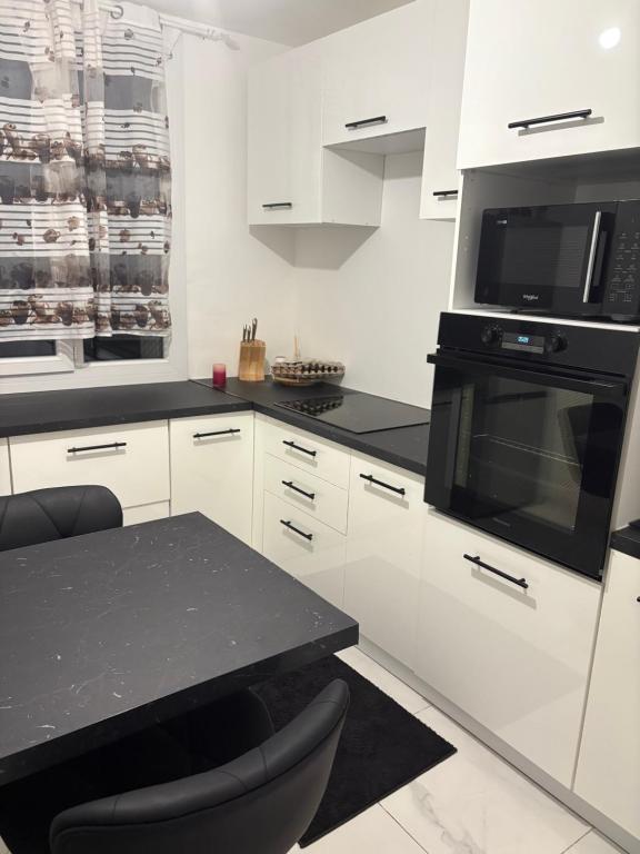 una cucina con mobili bianchi e un piano di lavoro nero di Groupama stadium arena eurexpo a Décines-Charpieu