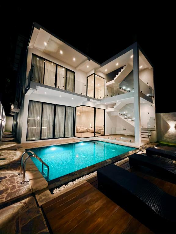 a house with a swimming pool at night at La Vizta Weligama in Weligama