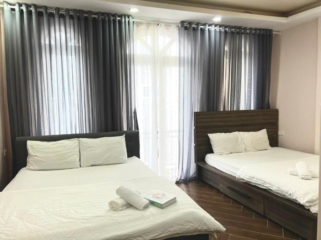ein Schlafzimmer mit zwei Betten und einem Fenster in der Unterkunft LALA HOUSE - CĂN HỘ Đà Lạt in Khu Chi Lăng