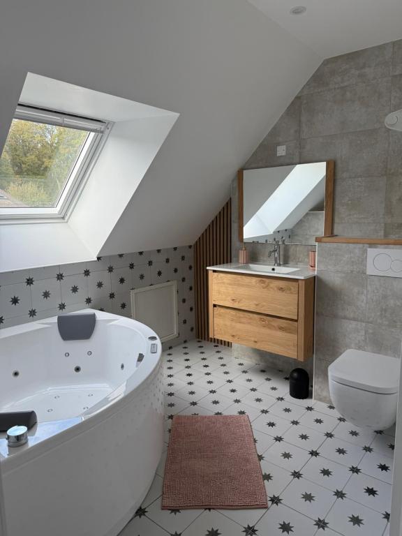 une salle de bain avec une baignoire, des toilettes et un lavabo dans l'établissement Ty Cocon - havre de paix avec jacuzzi, à Rochefort-en-Terre