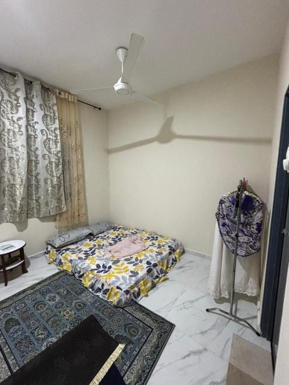 een slaapkamer met een bed en een tapijt erin bij Nora Guest House in Kerteh