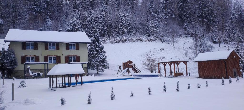 une maison et une aire de jeux dans la neige dans l'établissement 2chałupy - apartamenty w Soli, à Sól