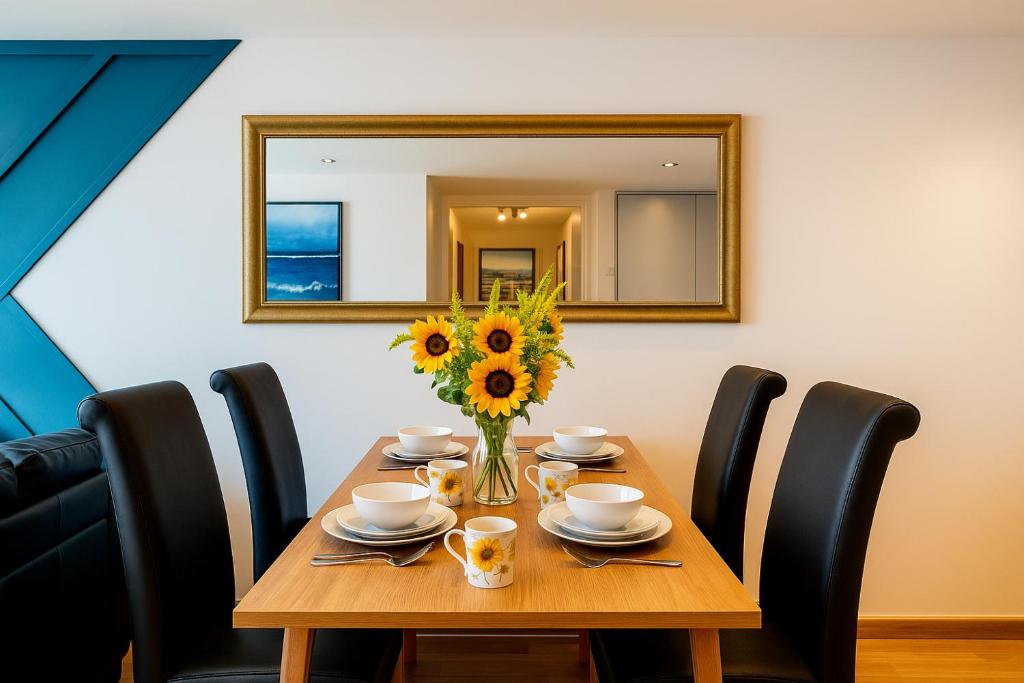 Sidemersey Livings- Convenient and Central 2-Bedroom Haven in L1, Secured Parking في ليفربول: طاولة مع مزهرية عباد الشمس ومرآة