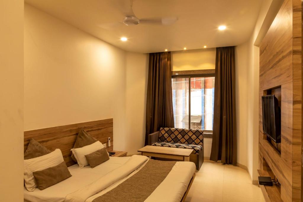 una habitación de hotel con una cama y una silla en Adarsh Palace Hotel Near Bhopal Railway Station and Nadra Bus Stand Bhopal, en Bhopal