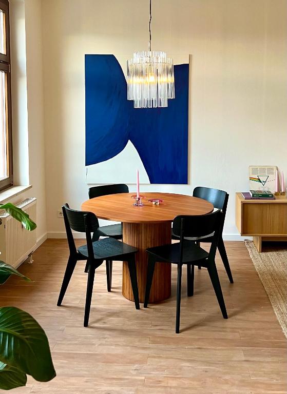 a dining room with a wooden table and chairs at Atelier Noé NOIR - Kunstvoll Wohnen - Wunderbares Frühstück möglich - Ruhig und nah am Zentrum - in Chemnitz