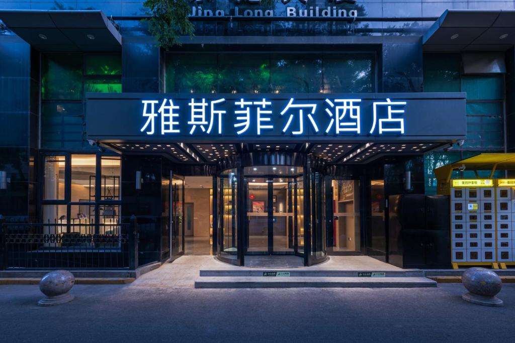 einen Eingang zu einem Gebäude mit einem Schild darauf in der Unterkunft Yasfield Hotel, Beijing Tuanjiehu Hujialou Subway Station Branch in Peking