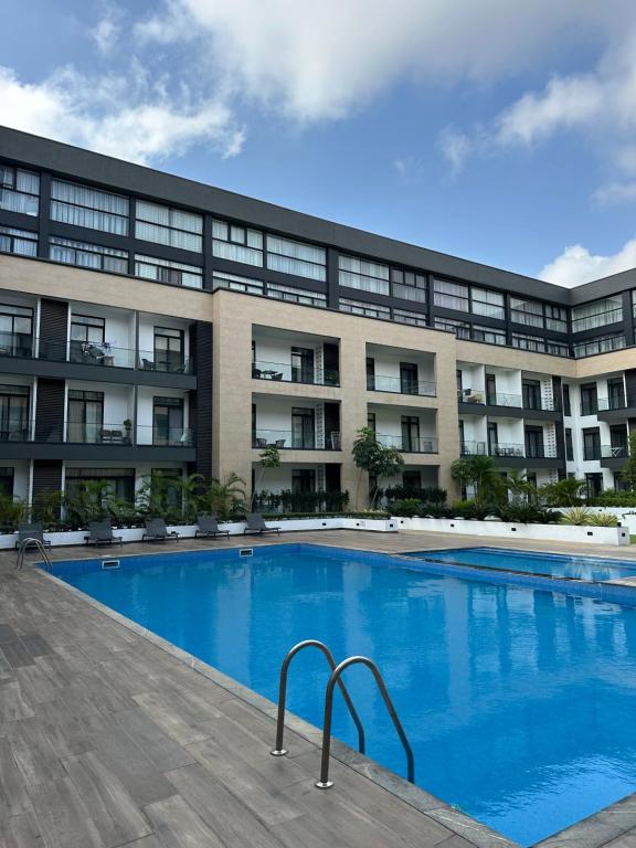 una piscina frente a un edificio en Peravi Suites At Embassy Gardens, en Trofwi