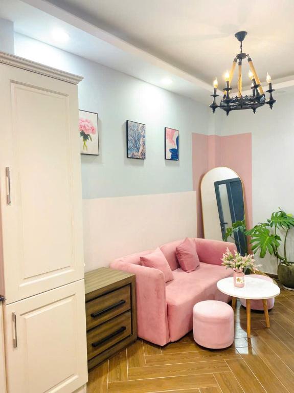 a living room with a pink couch and a mirror at Lá Home - Căn Hộ Đà Lạt in Khu Chi Lăng