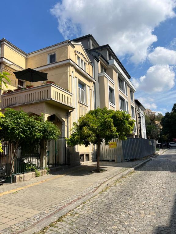 un bâtiment situé dans une rue avec un arbre en face de celle-ci dans l'établissement Студио Top City Center, à Plovdiv
