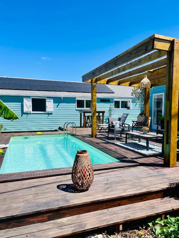 a swimming pool on a wooden deck next to a house at La case d'Édith in Le Tampon