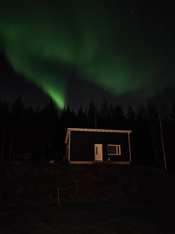 an image of a house with the aurora in the sky at Arctic Sauna Cabin in Rovaniemi