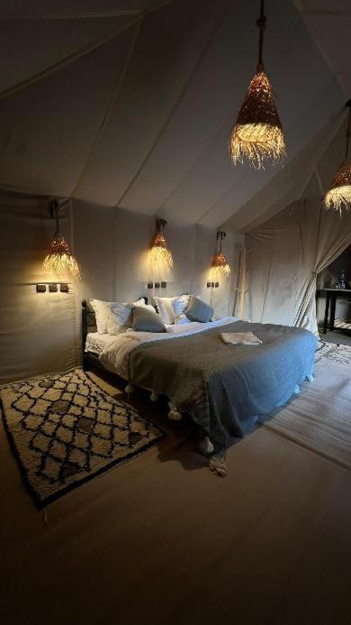 ein Schlafzimmer mit einem Bett in einem lichtdurchfluteten Zimmer in der Unterkunft Merzouga sunset camp in Merzouga