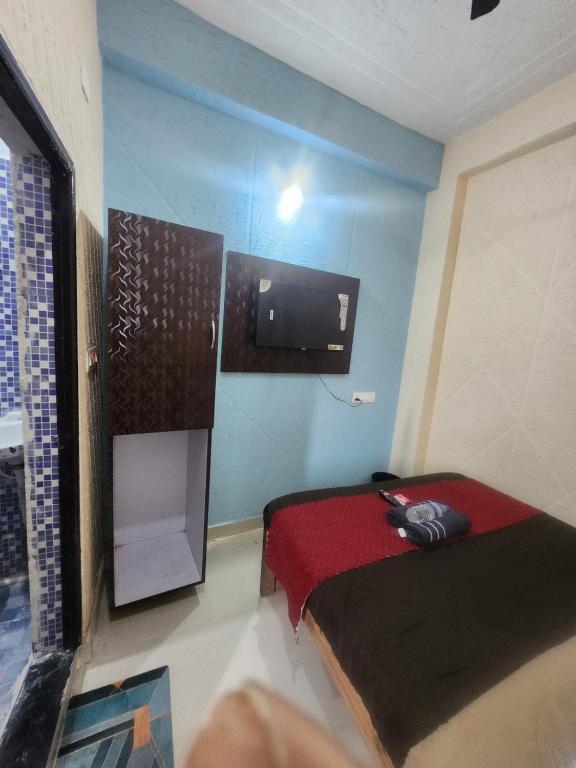 a small room with a bed and a television at SRT Homes Ranchi in Rānchī