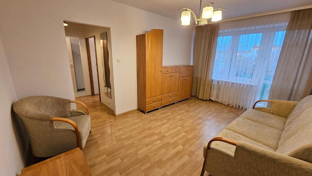 - un salon avec un canapé et des chaises dans l'établissement M przy Broniewskiego, à Łomża