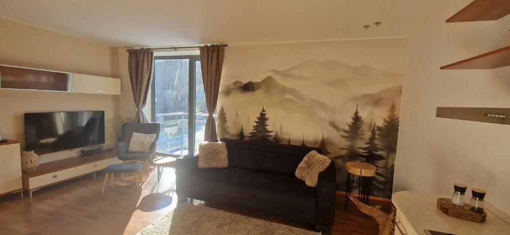 Una sala de estar con un mural de pared de montañas. en Apartment Mumlava falls, en Harrachov