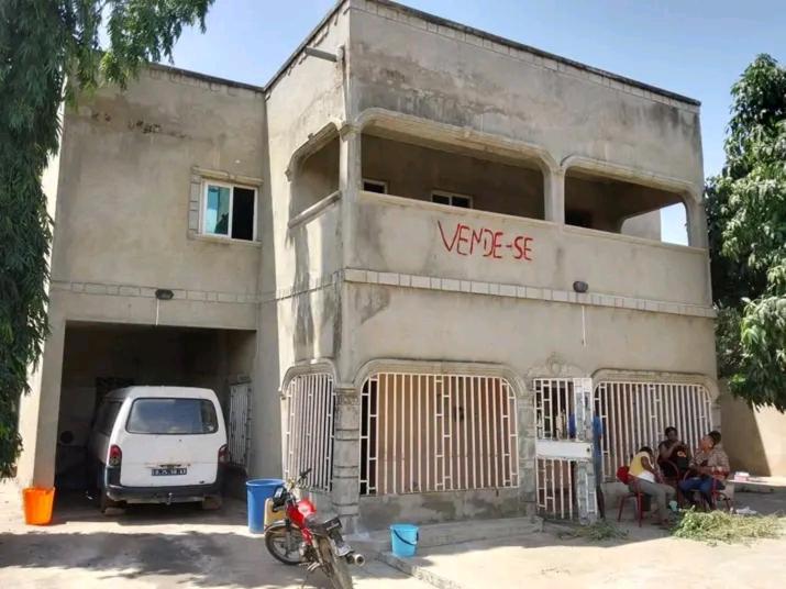 un grupo de personas sentadas afuera de un edificio en JUSTINO MENDES saidi, en Luanda