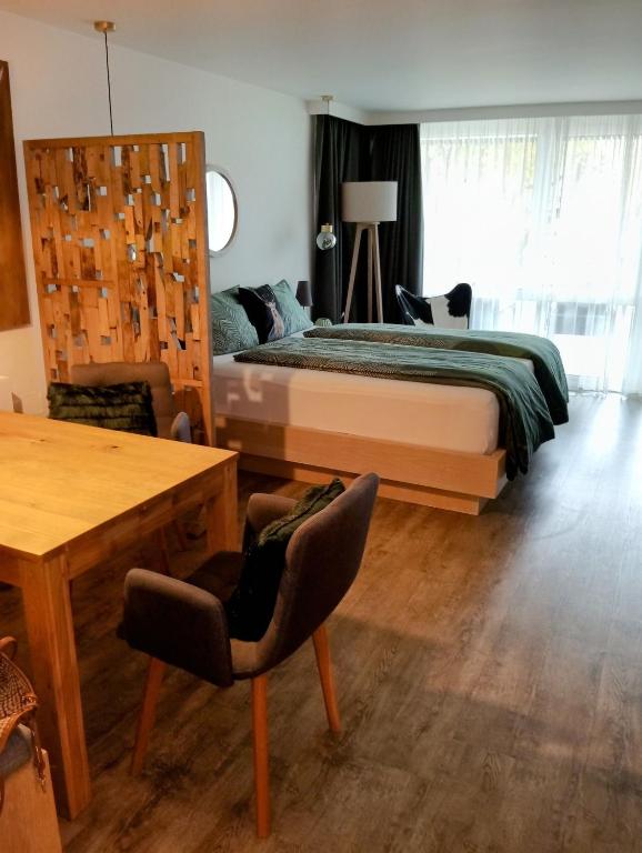 a bedroom with a bed and a desk and a chair at Maurers Schlierseetraum 6, Studio 455 mit 42 qm neu renoviert, Erdgeschoss mit eingezäunter Terrasse in ruhiger Lage am Kirchbichlweg 8 in Schliersee