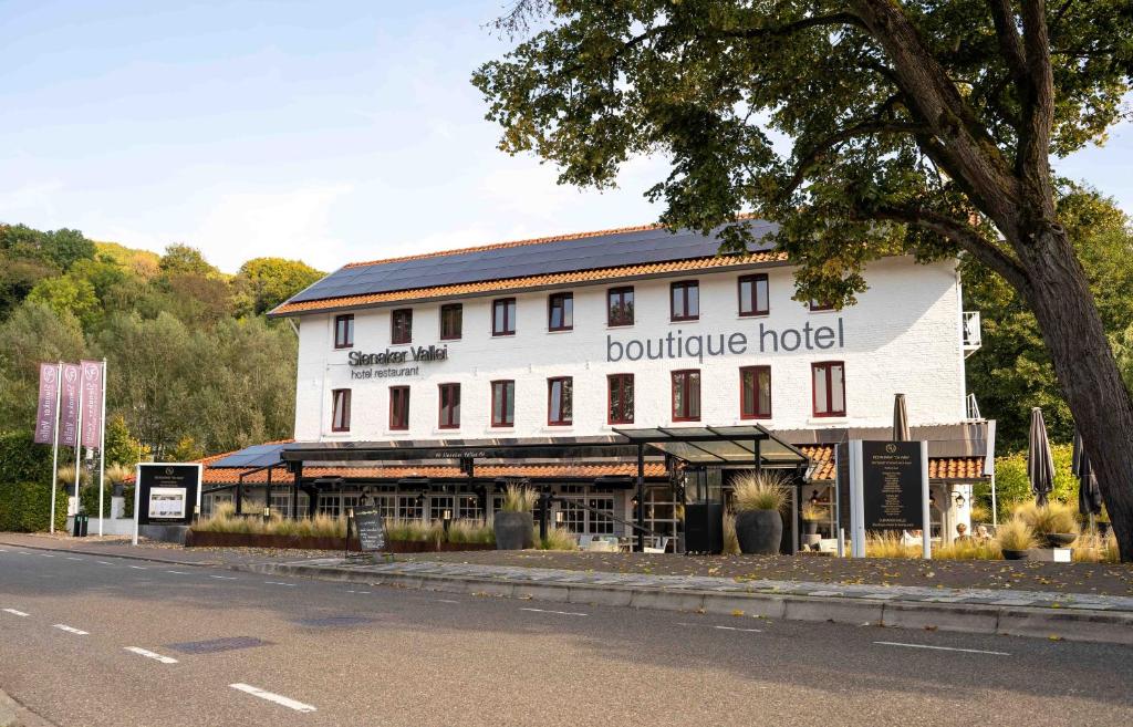 a white building with a boutique hotel on the side of the street at Boutique Hotel Slenaker Vallei - Buitengewoongenieten in Slenaken