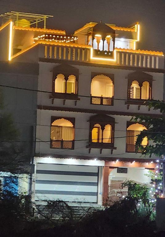 two people on the balcony of a building at night at Pratap Royal Stay in Ujjain