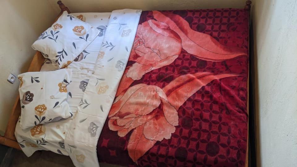 un gros plan d'une couverture avec des fleurs dessus dans l'établissement Akagera Homestay Experiences, à Rwinkwavu