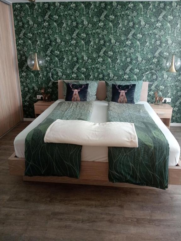 a bedroom with a large bed with green wallpaper at Maurers Schlierseetraum 1 hochwertige Erdgeschosswohnung mit allen Raffinessen erfreut sich auch Urlauber idealerweise für Paar mit Kindern geeignet und Vierbeiner Dank des tollen Zauns auf der Terrasse stylisch und edel von der Ausstattung mit 64 qm in Schliersee