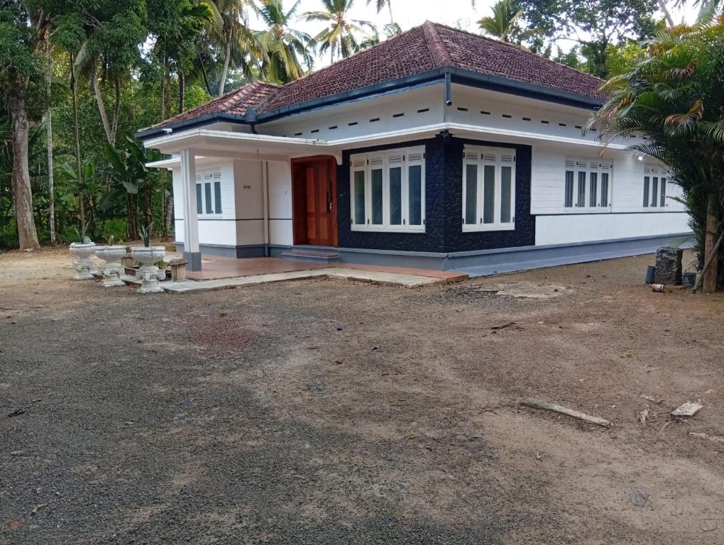 a small house with a red door at Crystal Waters in Habaraduwa