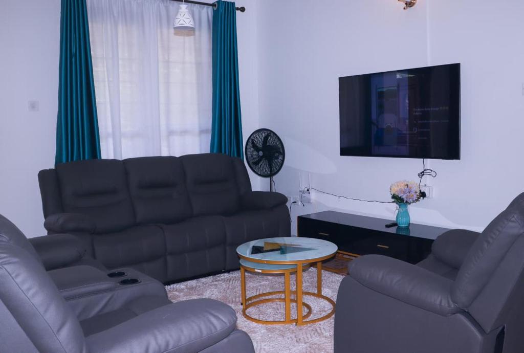 Una sala de estar con dos sofás y una mesa. en Rehema Apartments, en Kisumu