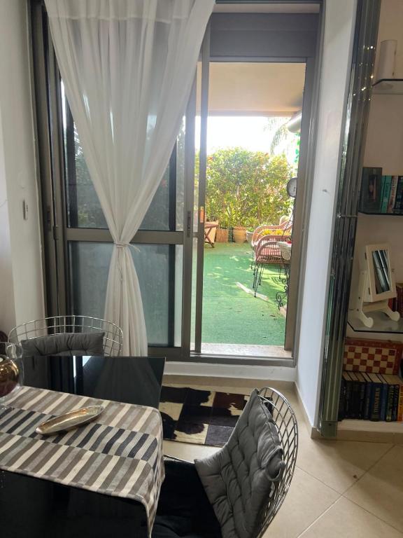 a room with a large window with a table and chairs at PARADISE in IR YAMIM in Netanya