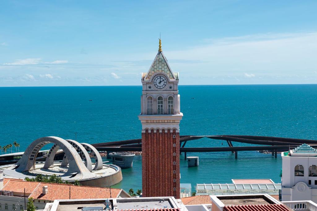 une haute tour d'horloge face à l'océan dans l'établissement Atermis Regency Hillside Phu Quoc - Sea & Fireworks view- Gym & Pool Access, à Duong Dong