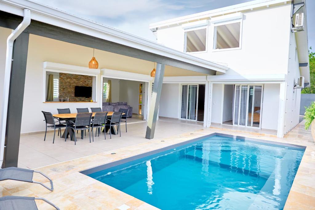 a house with a swimming pool in front of a house at Écrin d'évasion in Sainte-Anne