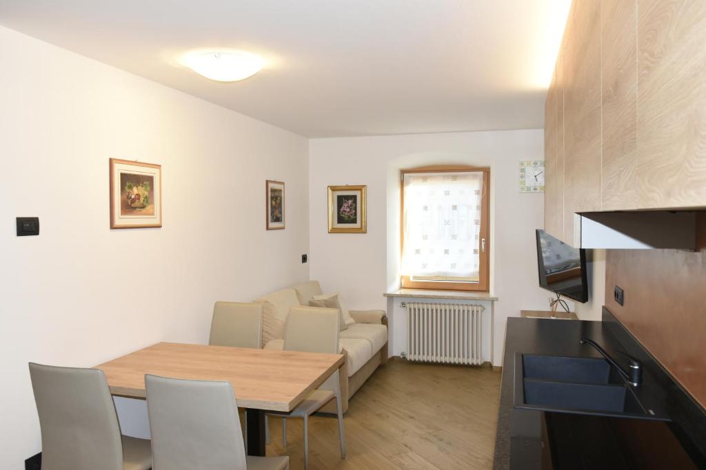un soggiorno con un tavolo e un divano di Appartamento Margherita a Panchia