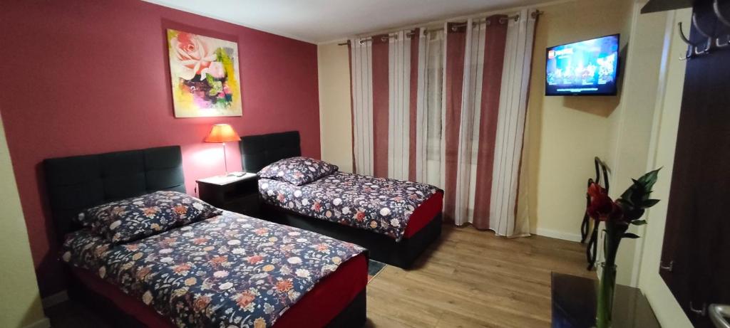 une chambre d'hôtel avec deux lits et une télévision à écran plat dans l'établissement Die Hotelalternative Michael Treiber 5, à Solingen